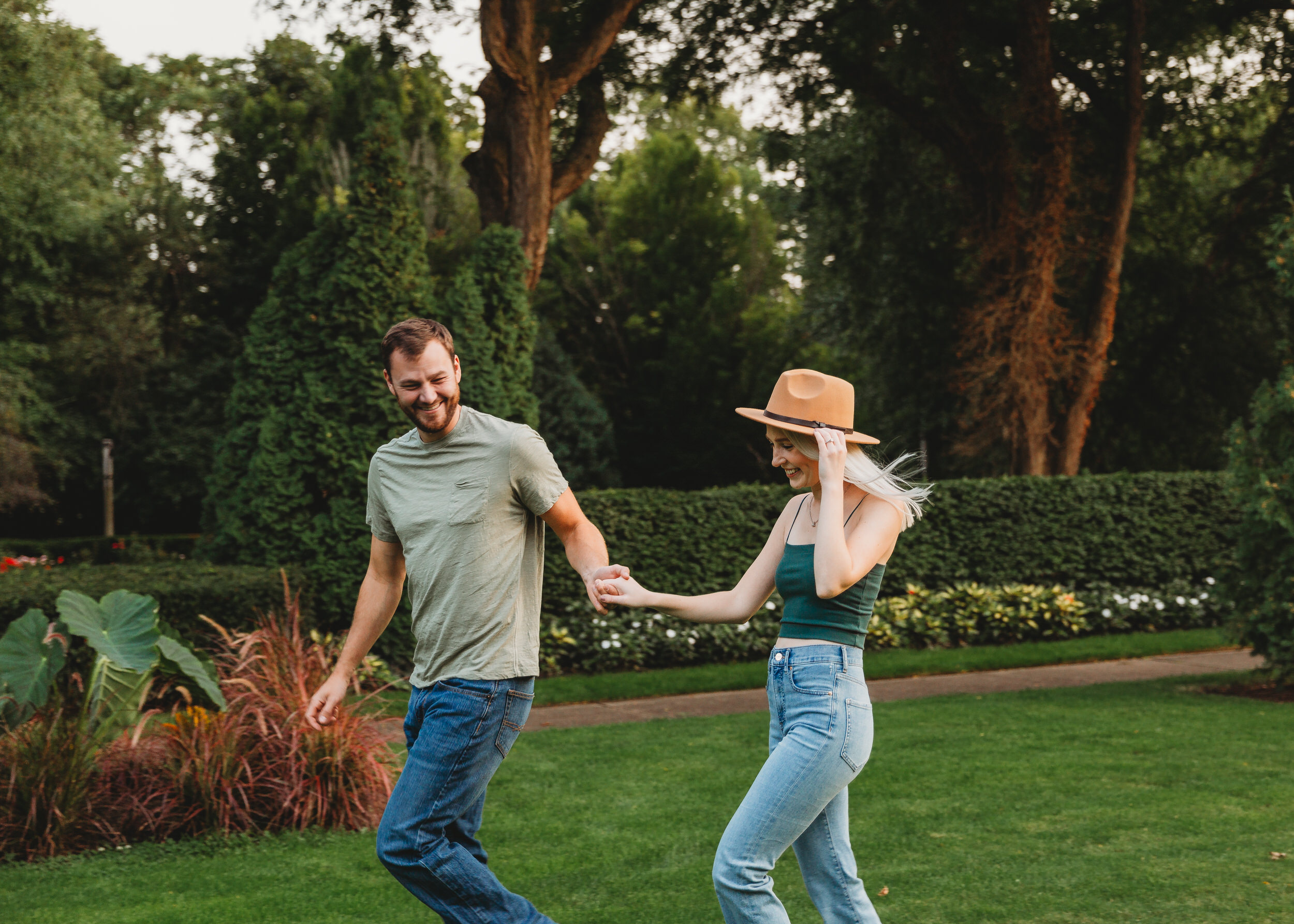Man and woman walk hand in hand in a Michigan garden