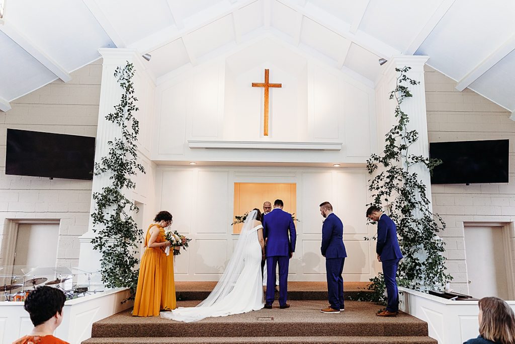 church wedding with bride and groom praying