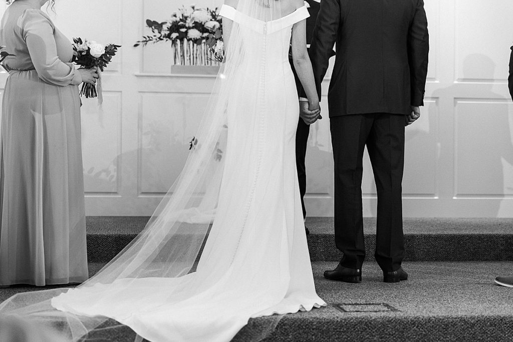 black and white photo of bride and groom holding hands
