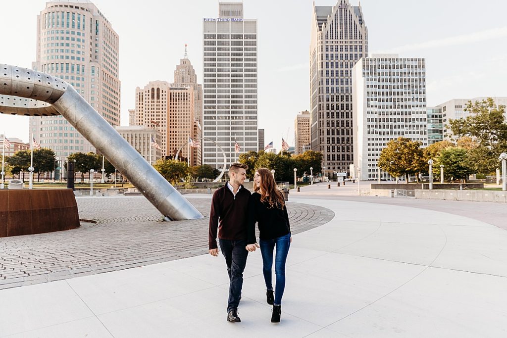 couple walking holding hands in downtown detroit