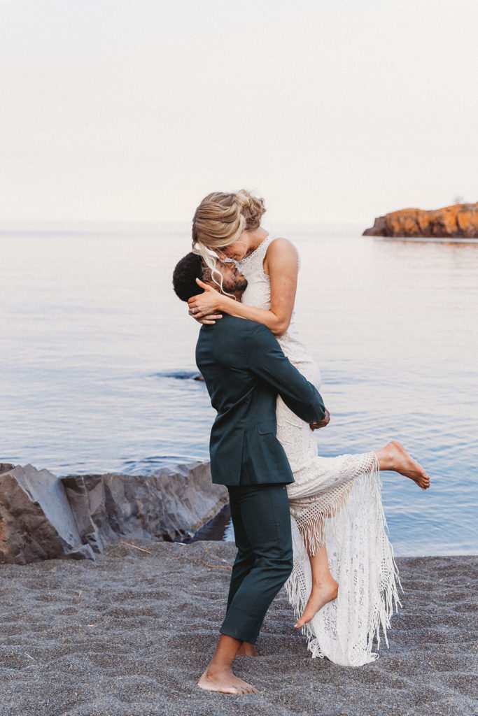 couple standing on beach during adventure elopement