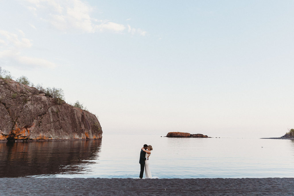 couple standing on beach at elopement