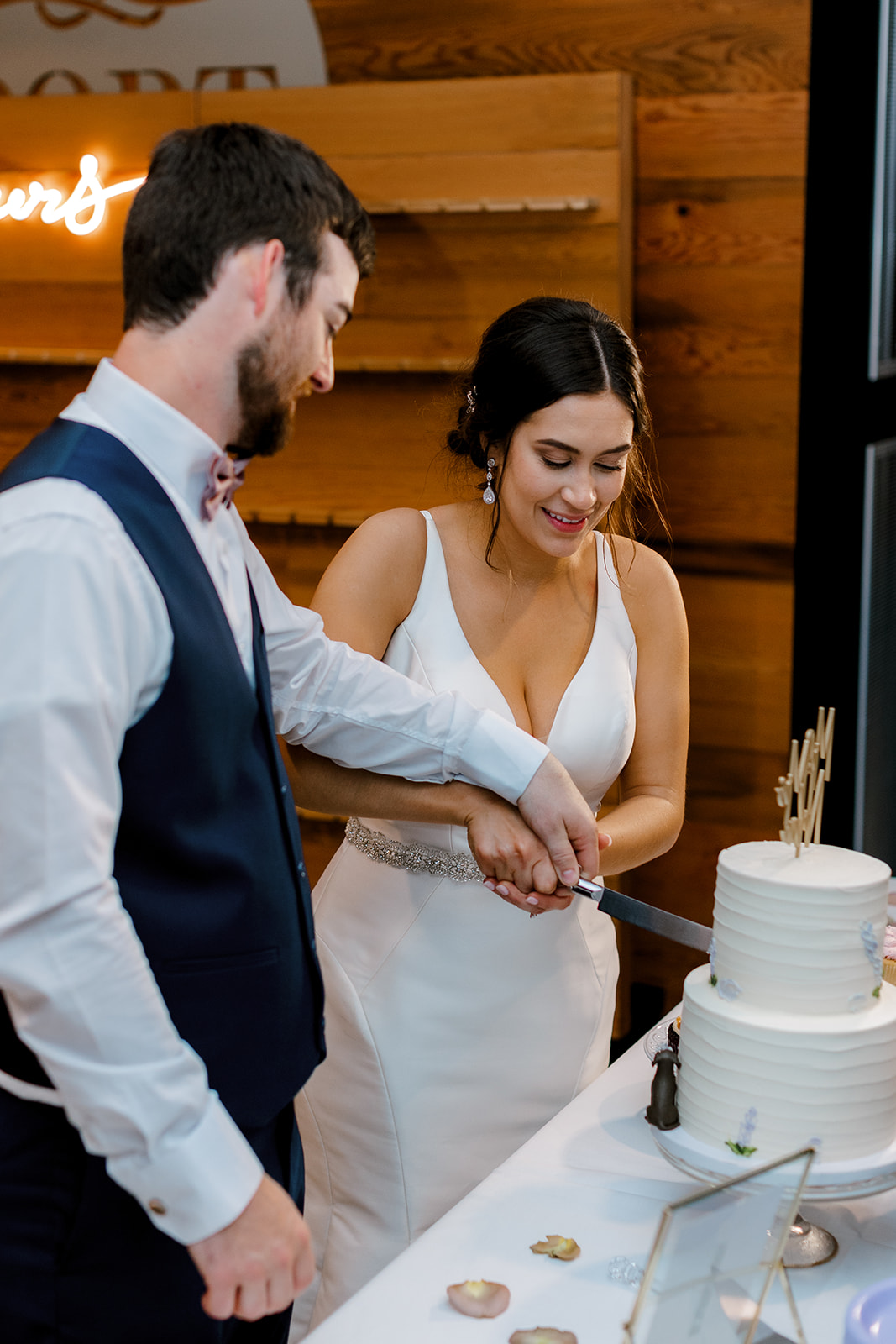 bride and groom cutting their wedding cake with Michigan wedding photographer