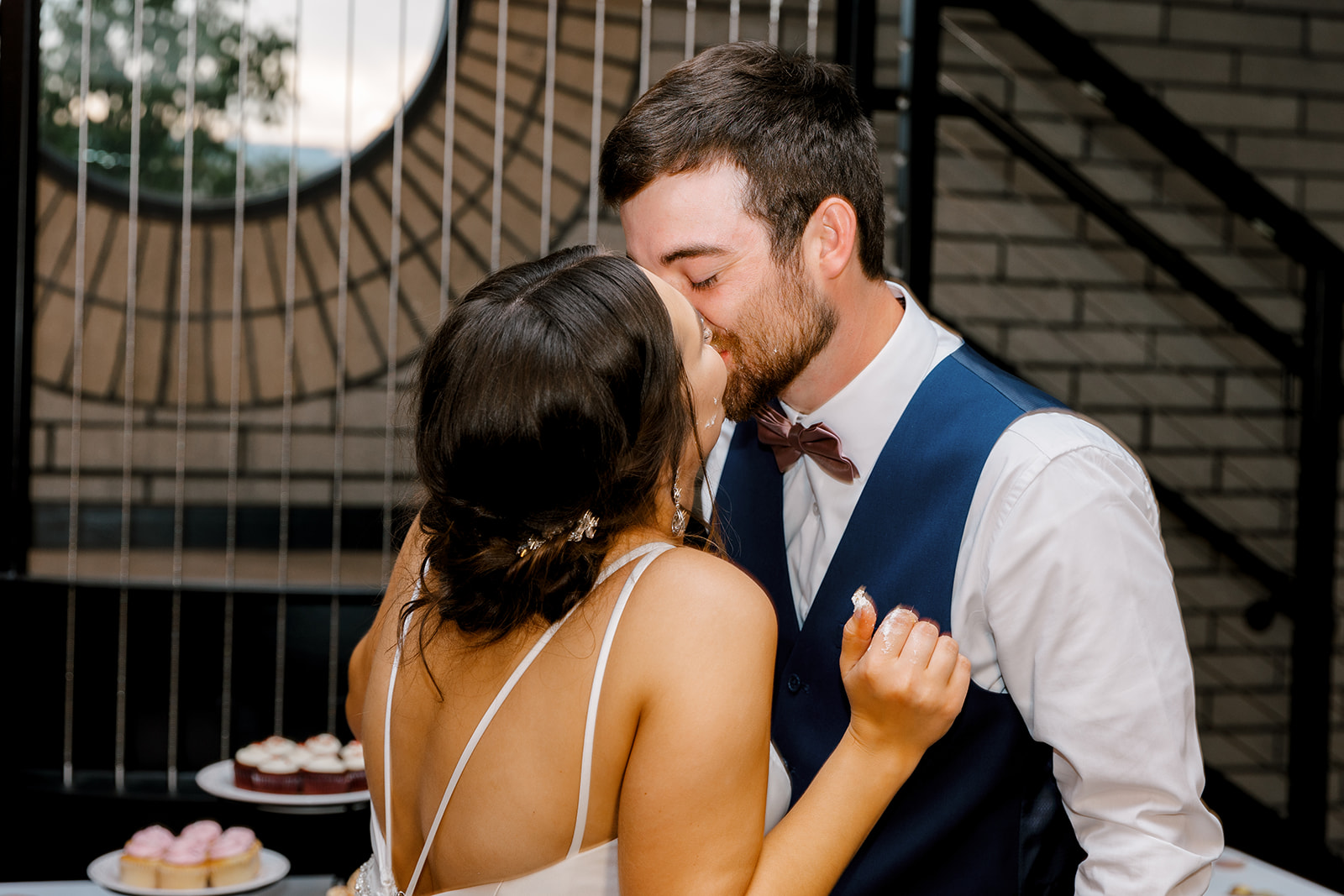 bride and groom kissing during the cake cutting with Michigan wedding photographer