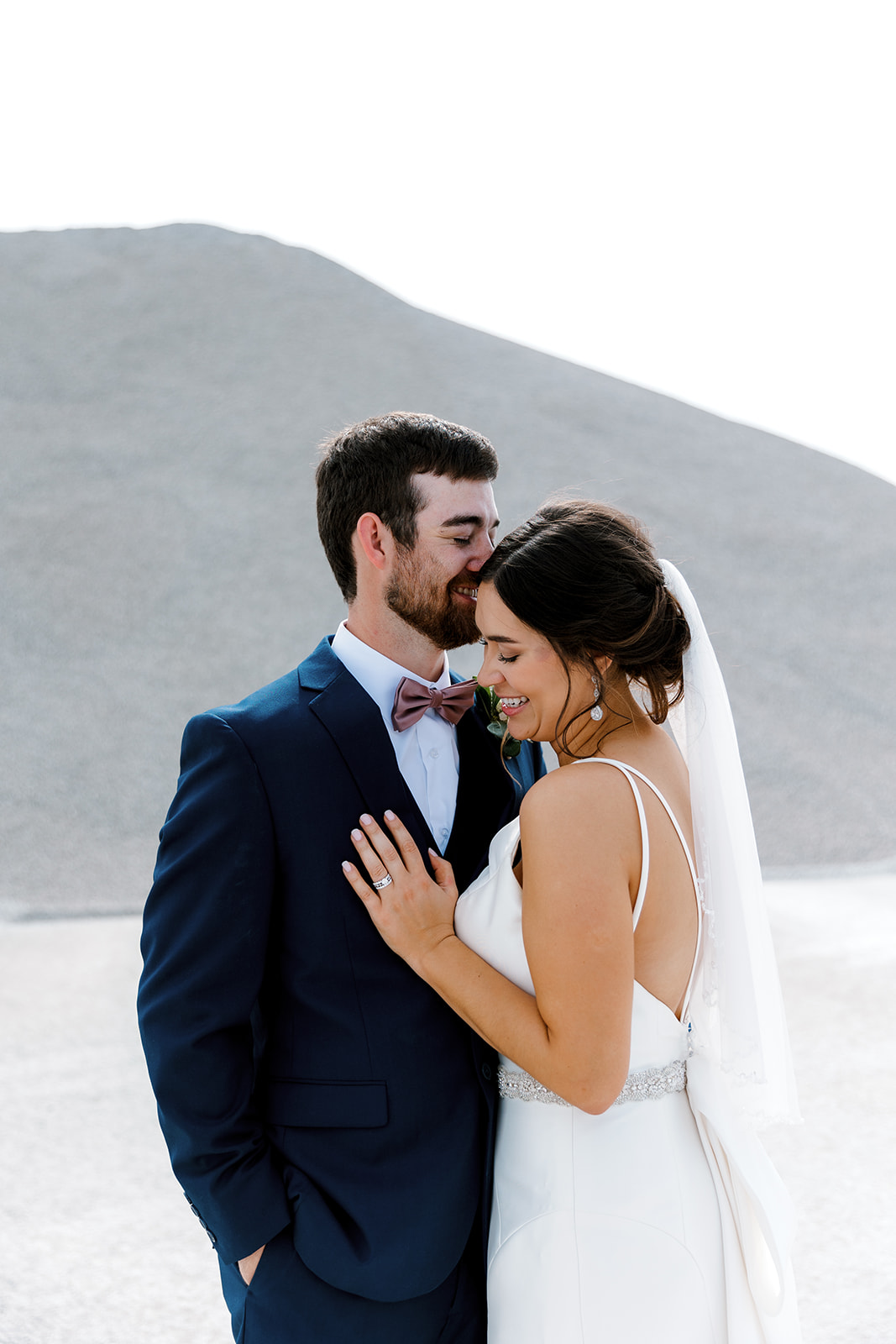 groom kissing brides head with Michigan wedding photographer