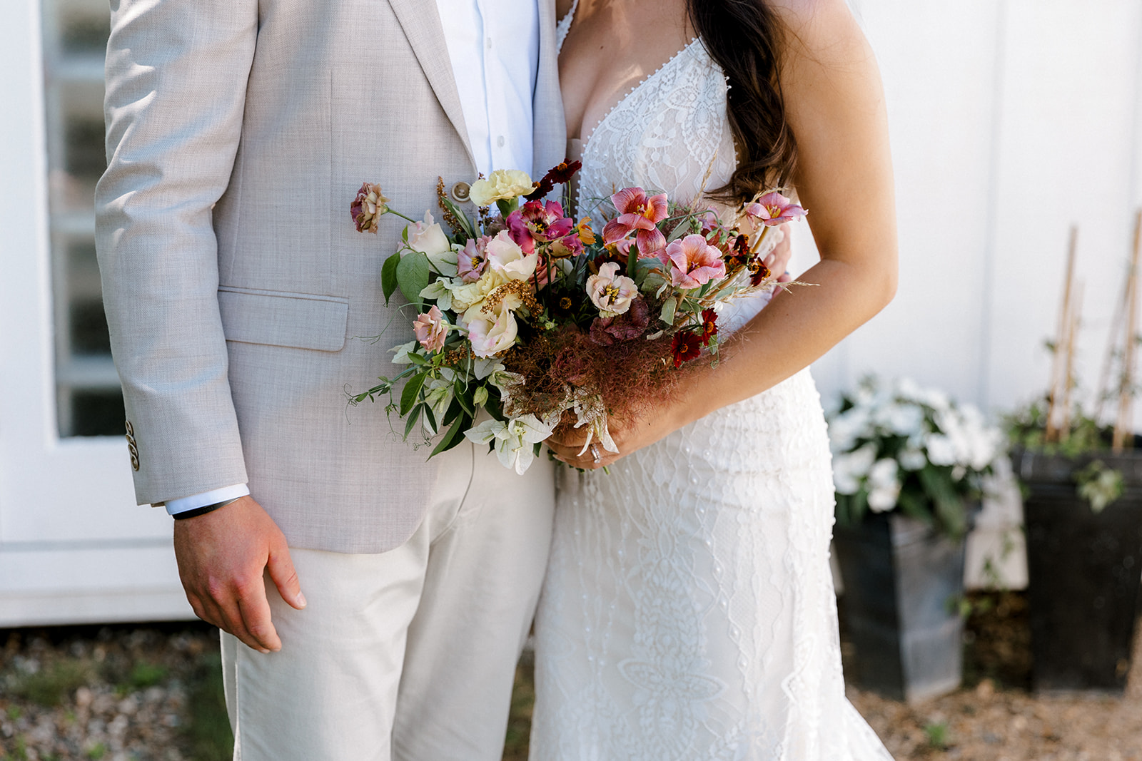 a photo of the bride and groom holding the bridal bouquet