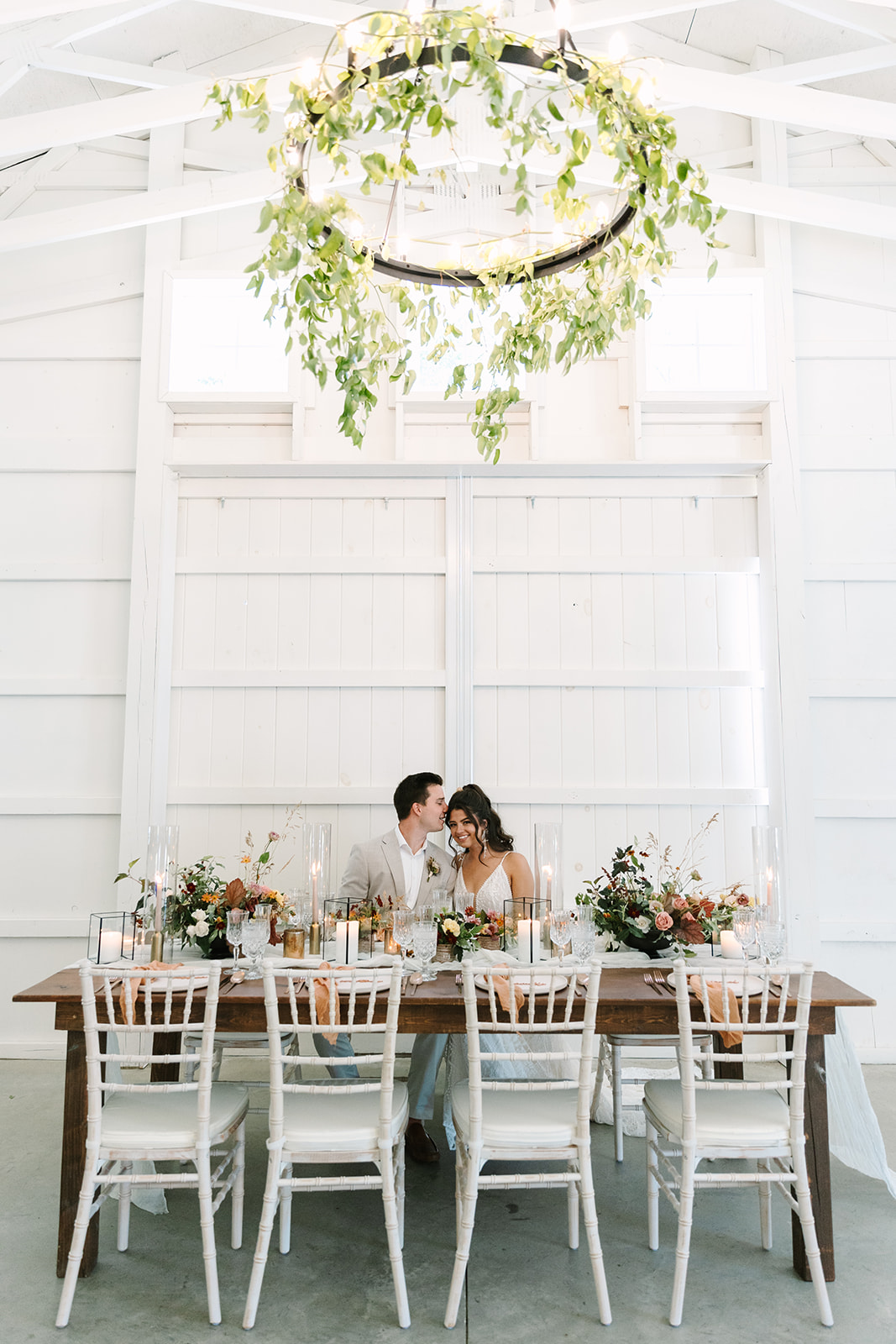 bride and groom cuddling at their wedding table filled with wedding decor