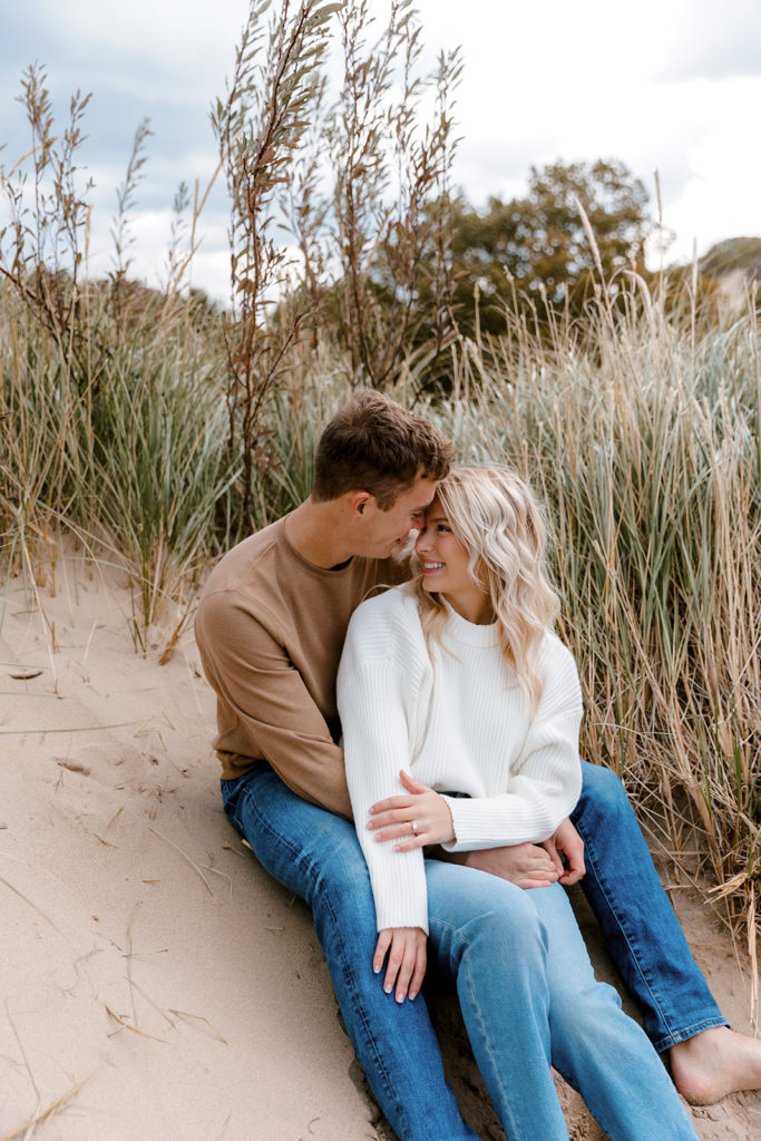 couple posing on the beach for their engagement photos in michigan