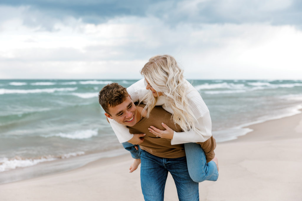 couple posing on the beach for their engagement photos in michigan