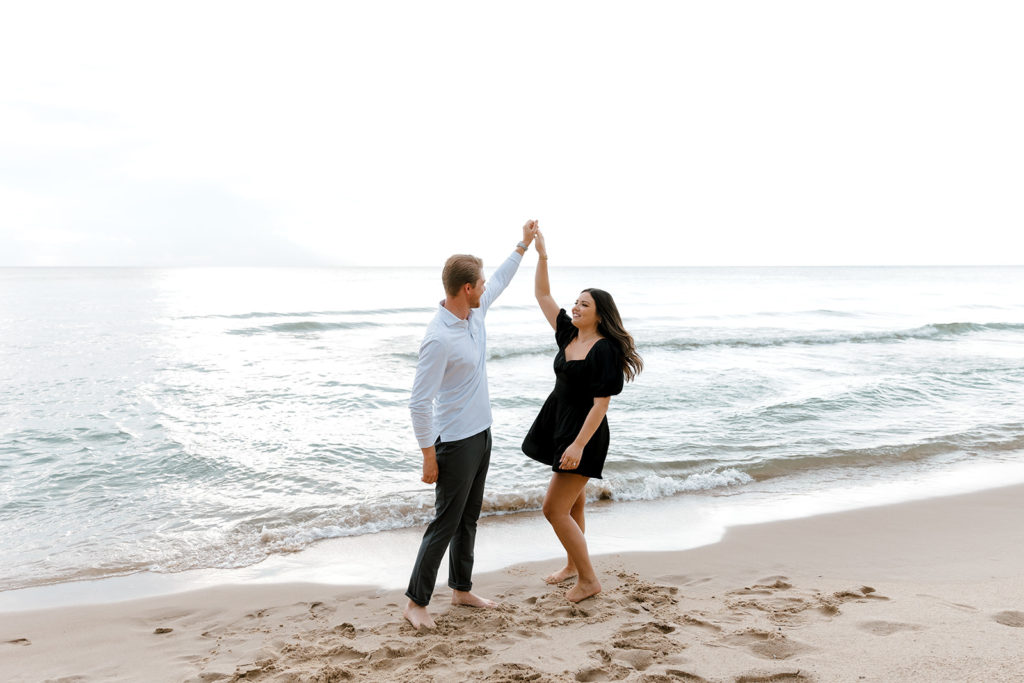 Couple dancing on the beach during engagement session