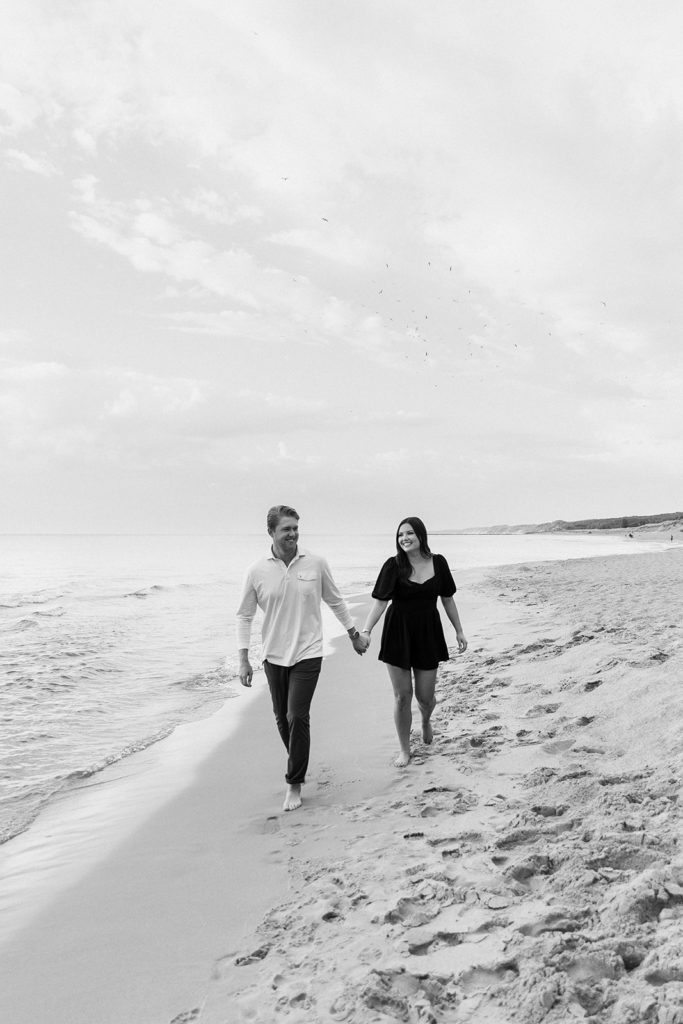 Couple walking the beach during engagement session 