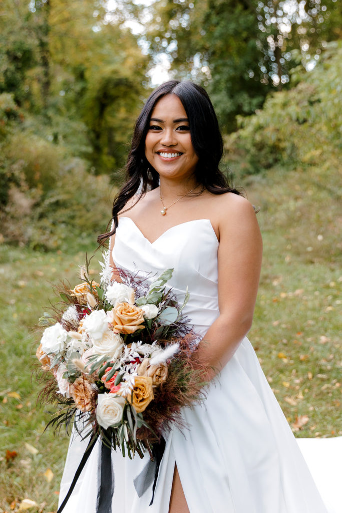 bride posing with flower bouquet for wedding photo