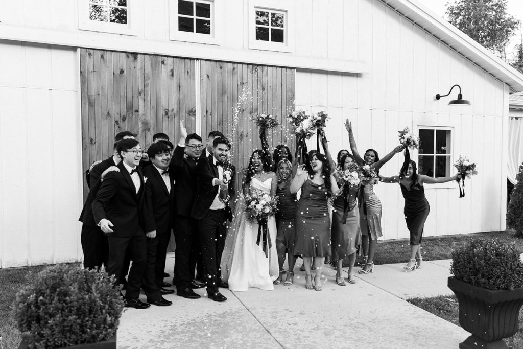 entire bridal party posing for photos with confetti 
