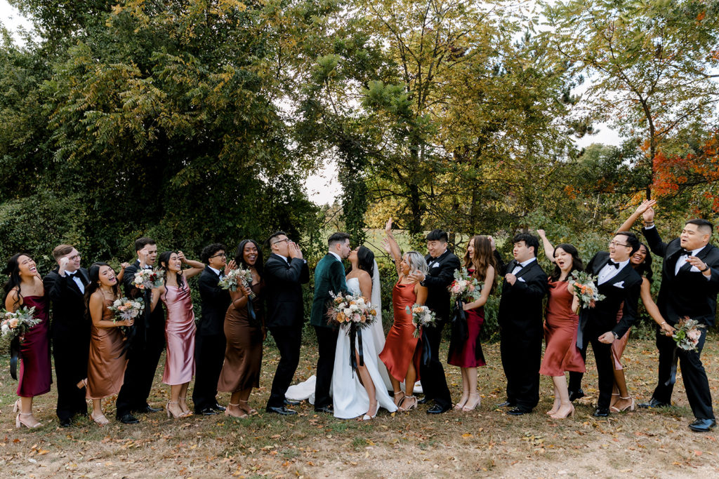 entire bridal party posing for wedding photos after wedding in mi