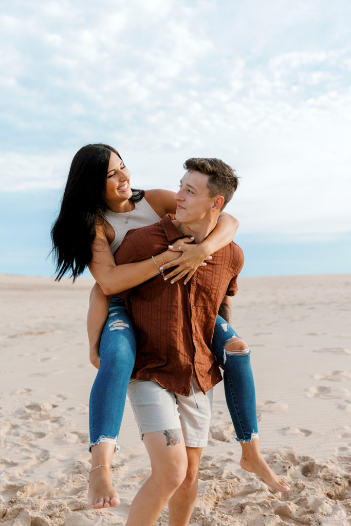 couple being playful together at michigan sand dunes