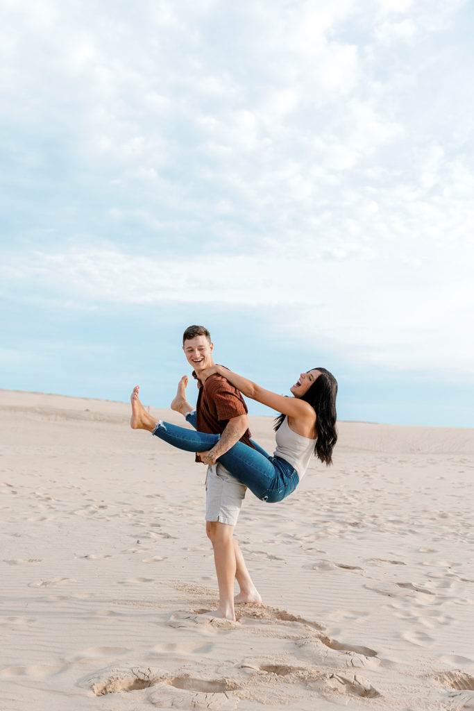 couple being playful together at michigan sand dunes