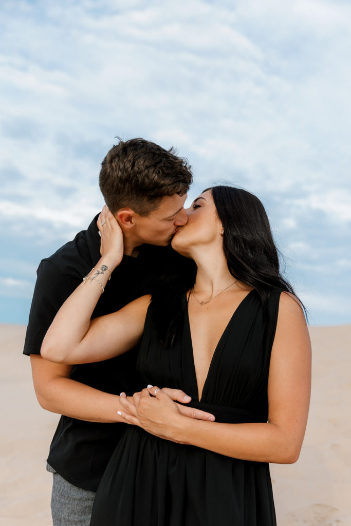Couple posing for photos at the sand dunes in michigan