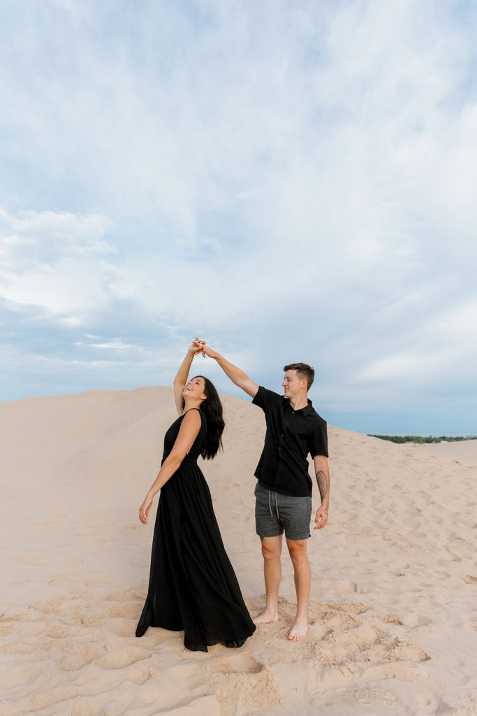 Couple posing for photos at the sand dunes in michigan