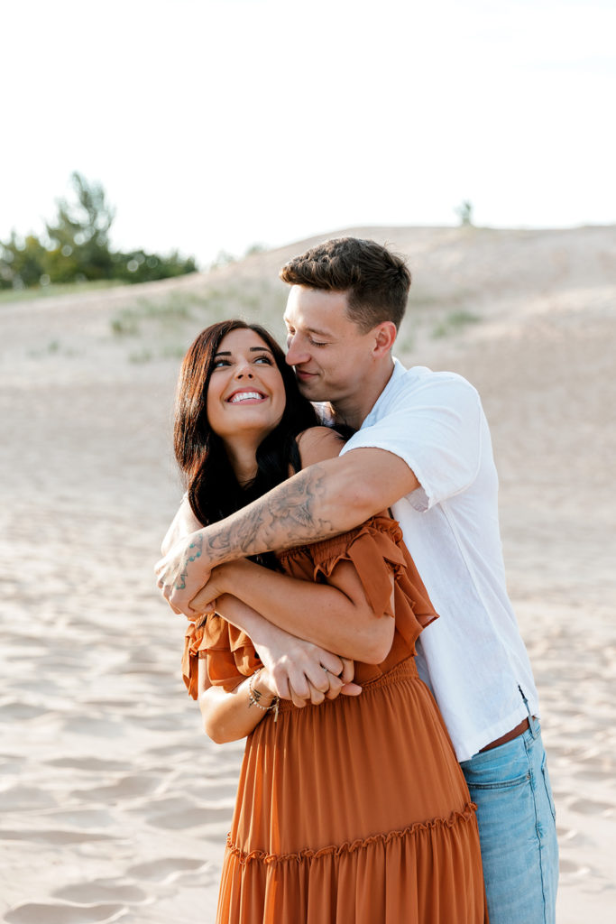 Couple posing for photos at the sand dunes at silver lake in mi