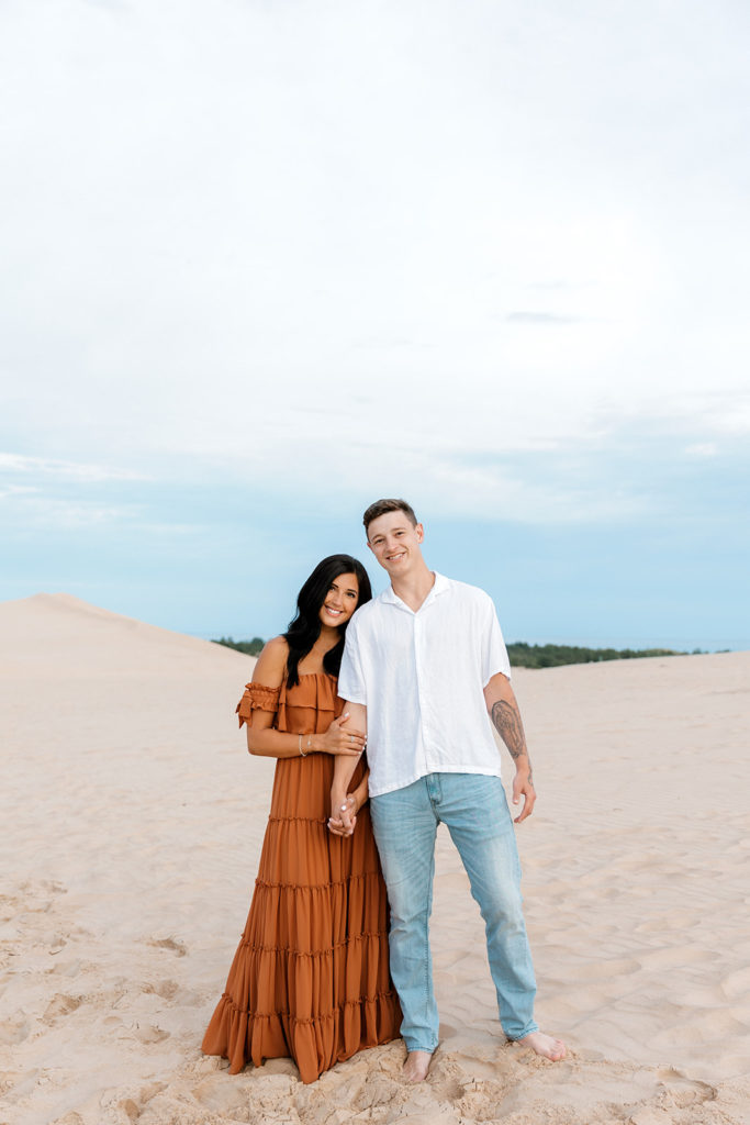 Couple posing for photos at the sand dunes at silver lake in mi