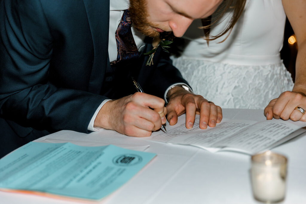 groom signing marriage license