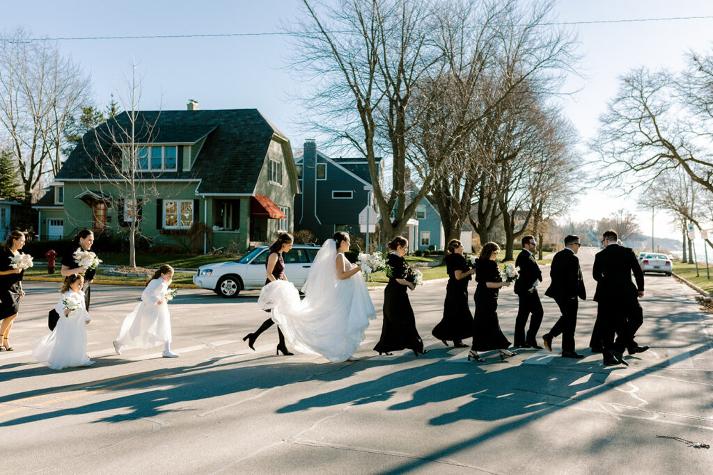 Bride and groom walking to the wedding venue with bridal party