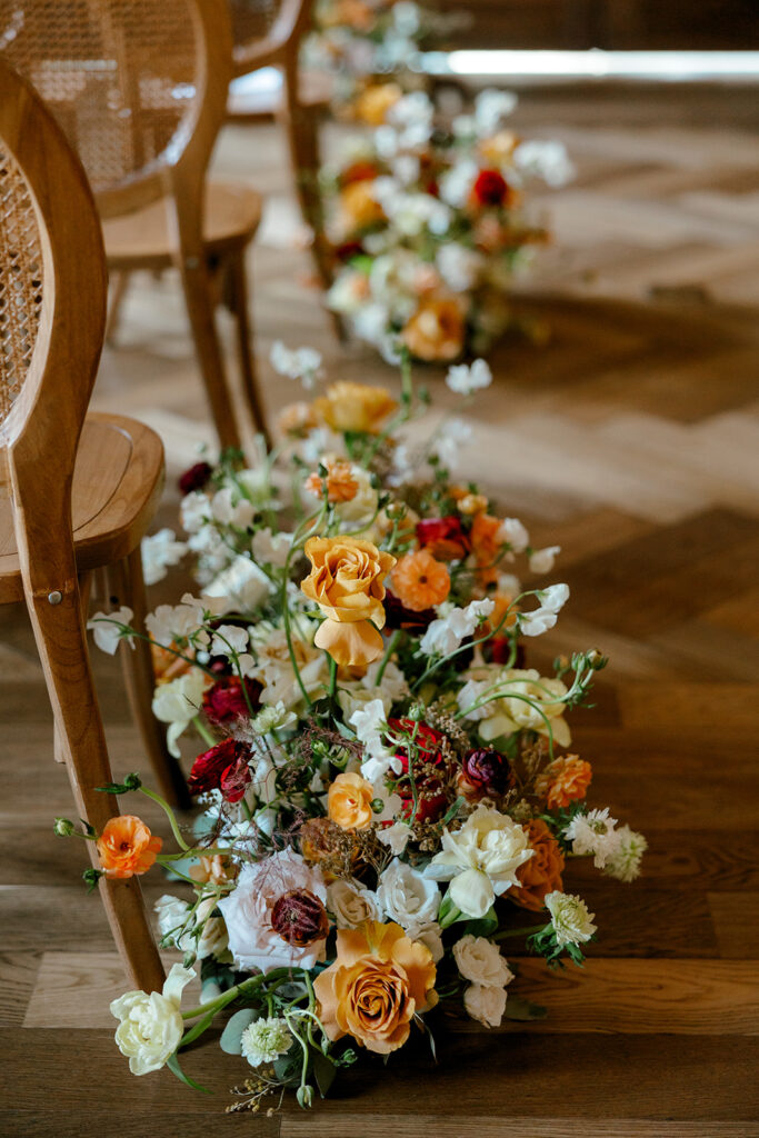 Lush, garden-style florals line the aisles of mocha-themed wedding at Book Tower wedding venue