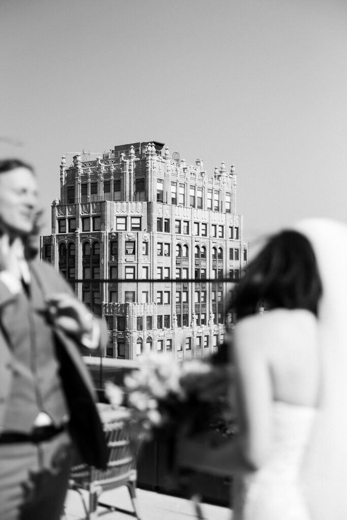 Bride and groom stand on rooftop of Book Tower wedding venue in downtown Detroit at their mocha-themed wedding