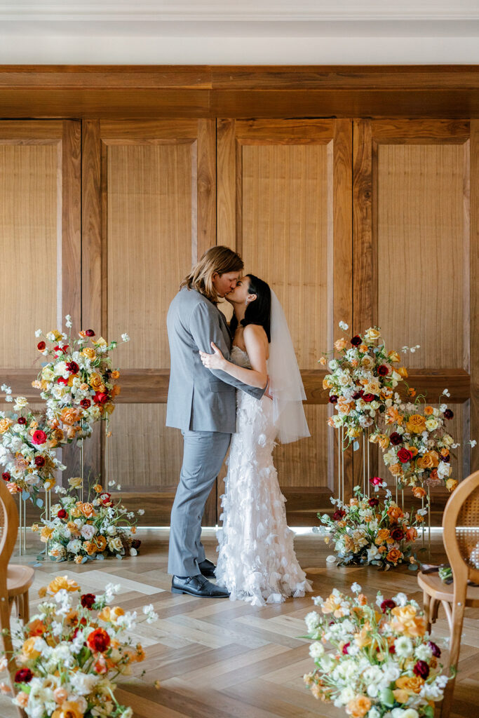 Newlyweds kiss at their trendy, luxury mocha-themed wedding at Anthology Events at Book Tower 