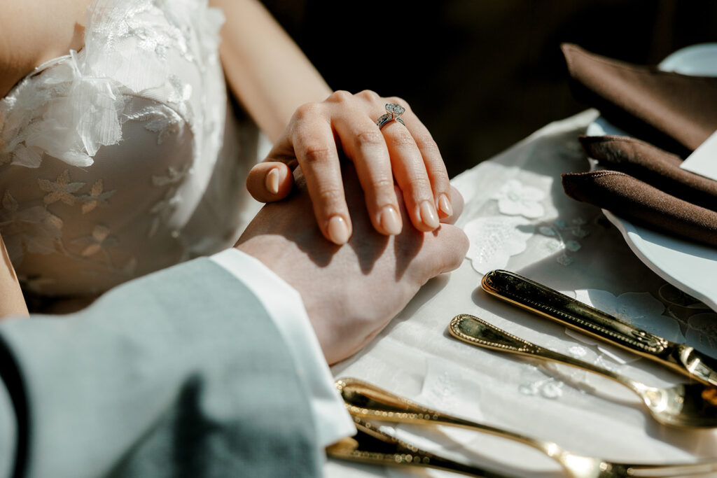 Bride gingerly lays her hand on groom's at mocha themed wedding 