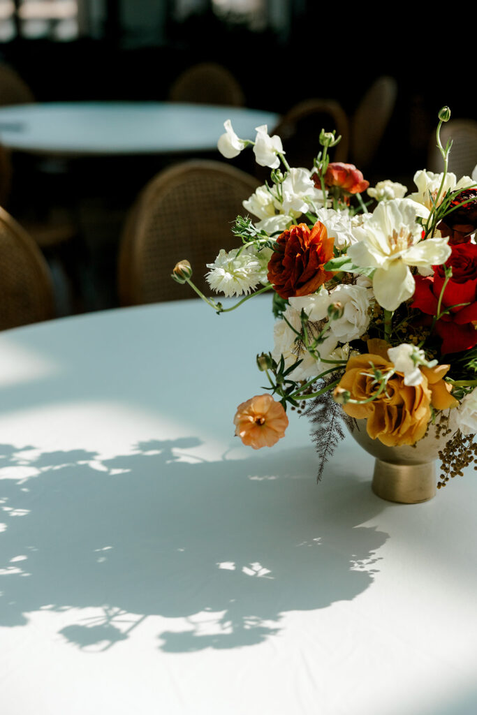 Silhouette of vibrant florals reflected on white linen tablecloth