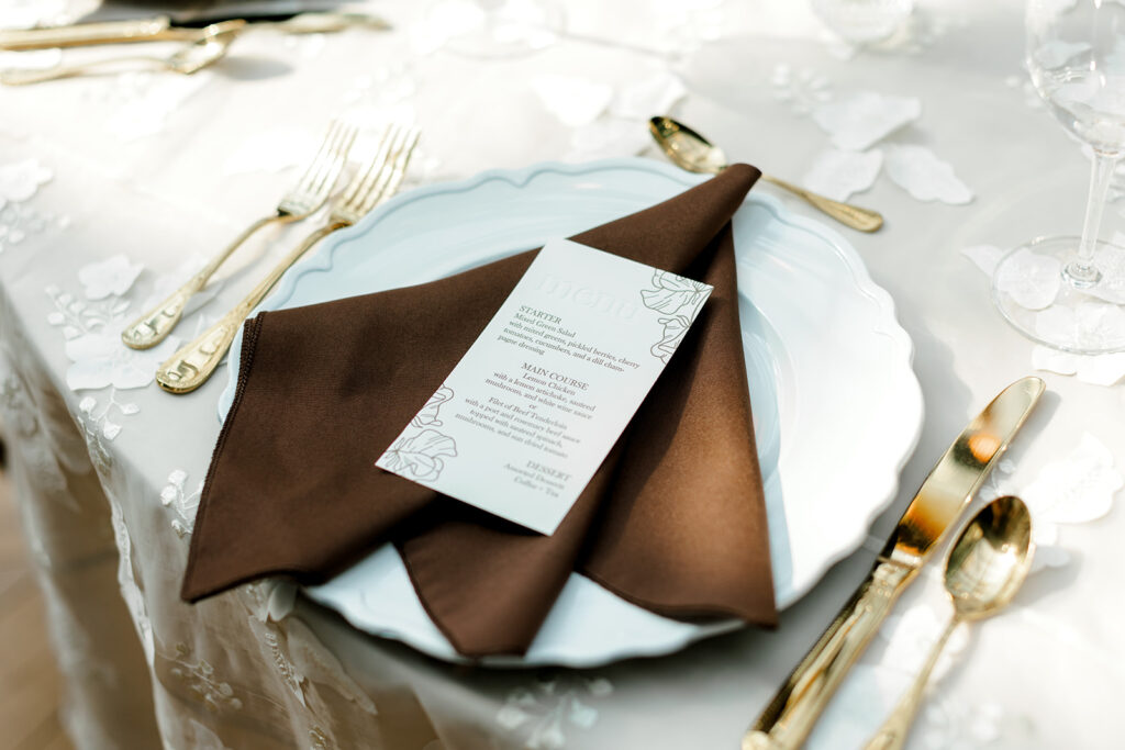 Mocha-themed wedding tablescape complete with mocha linens and gold cutlery