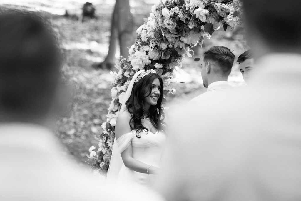 Bride grins adoringly at her groom during wedding ceremony