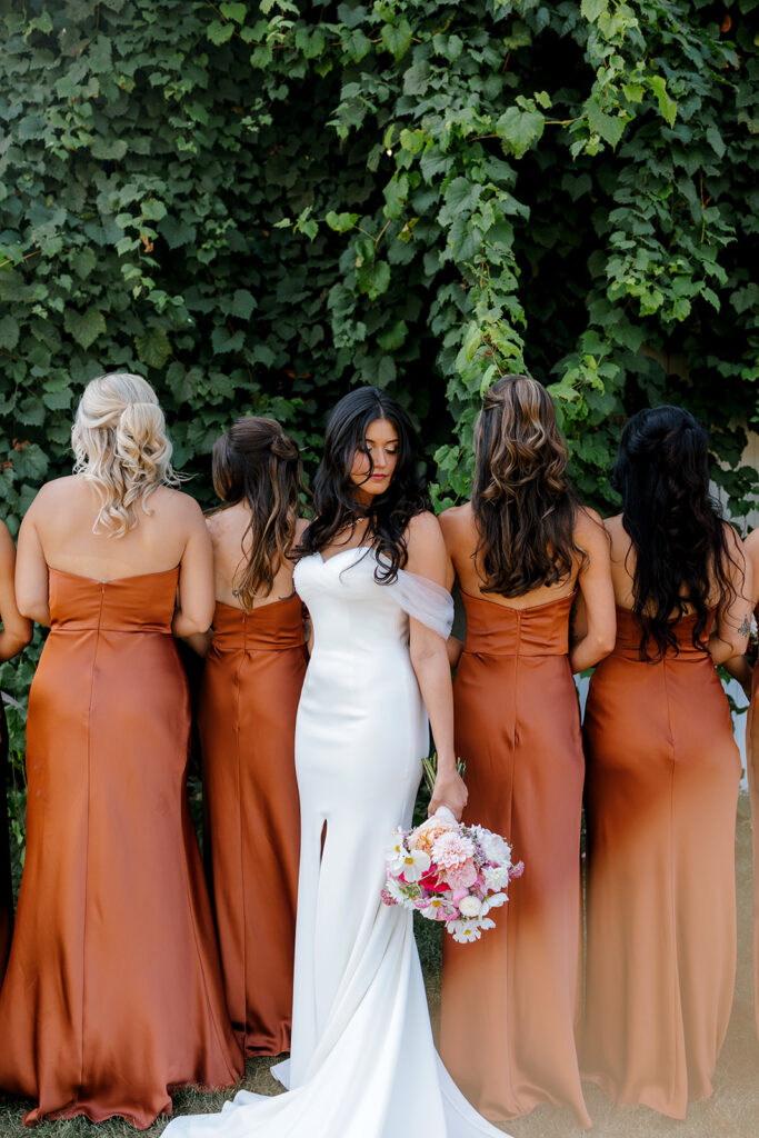 Bride looks over her shoulder while standing alongside her bridesmaids