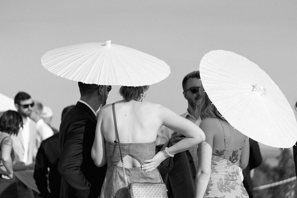Wedding guests hold dainty parasols at Michigan wedding cocktail hour