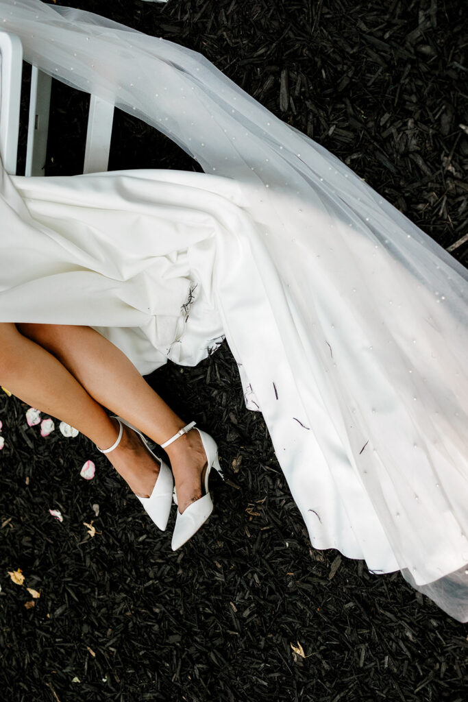 Bride's shoes and dress lay in the dirt