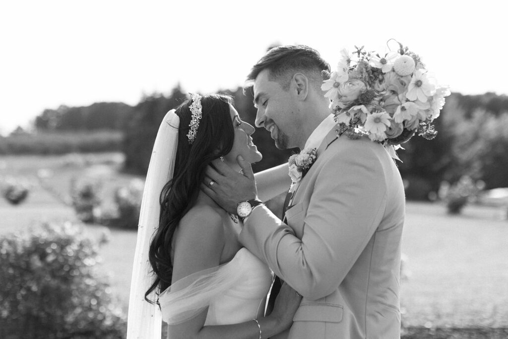 Groom gently holds bride's face in his hands in editorial style candids for Michigan wedding