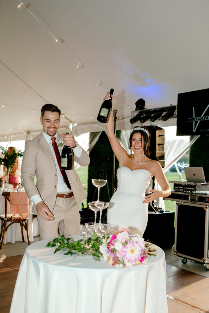 Newlyweds raise bottles of champagne in the air