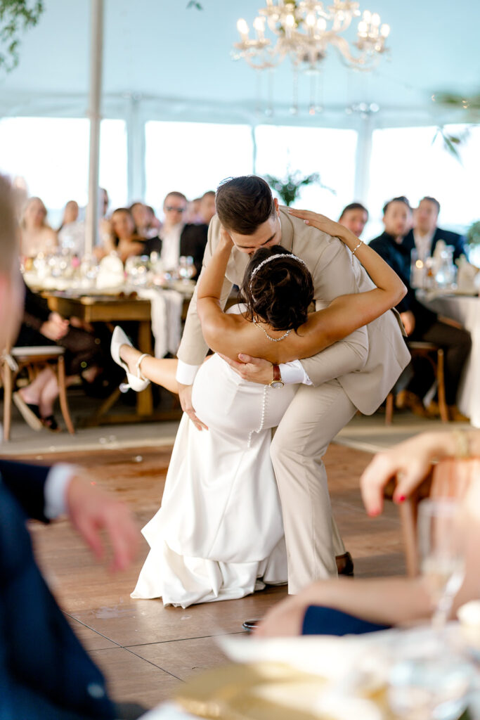 Groom dips bride during dance