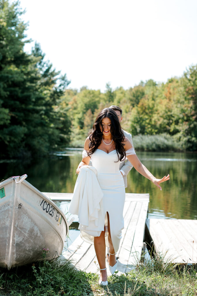 Bride gingerly minds her step in editorial style candids as she makes her way off the dock where she had her first look with her groom