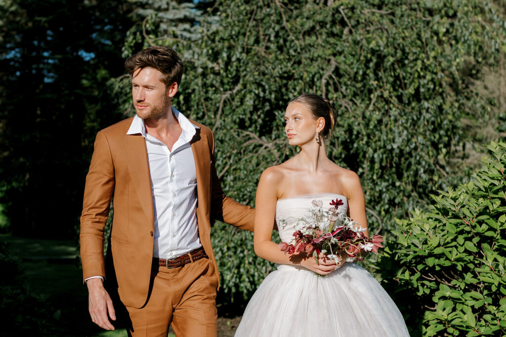 Bride looks adoringly as sharply-dressed groom in camel suit