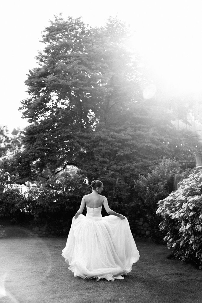 Bride dances down manor lawn at European style wedding venue