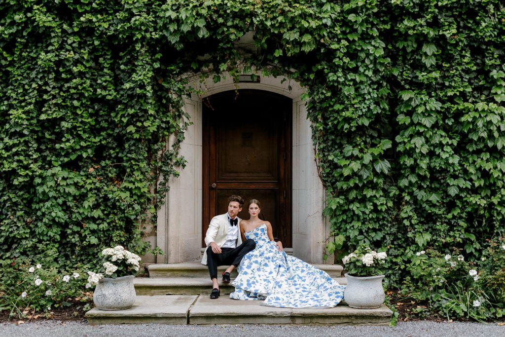 Bride and groom framed by the ivy-covered façade of the manor at European style wedding venue