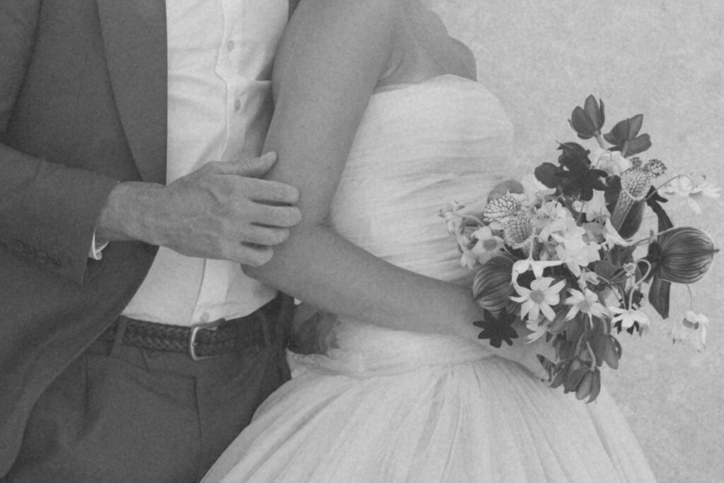 Close crop of bride and groom in front of stone wall at Greencrest Manor