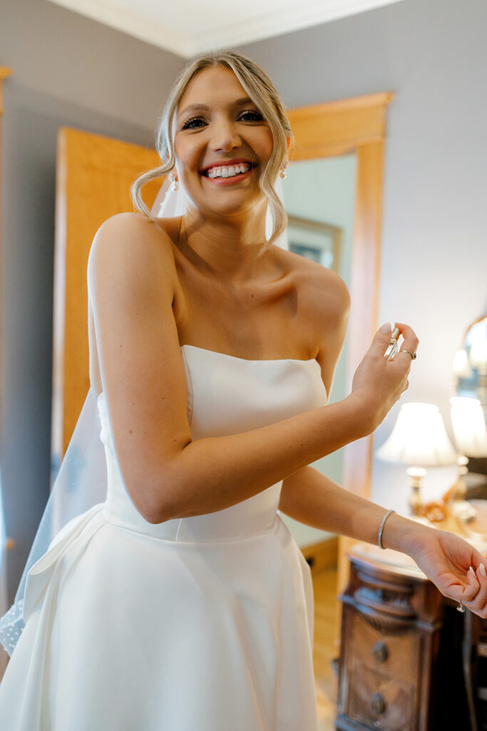 Bride smiling as she prepares for the ceremony, a perfect candid for documentary-style Michigan wedding photography.