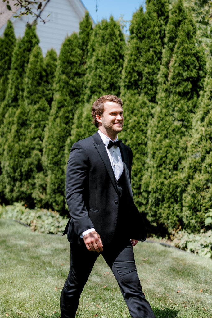 Groom walking toward bride for first look, a joyful candid moment from a Michigan wedding.