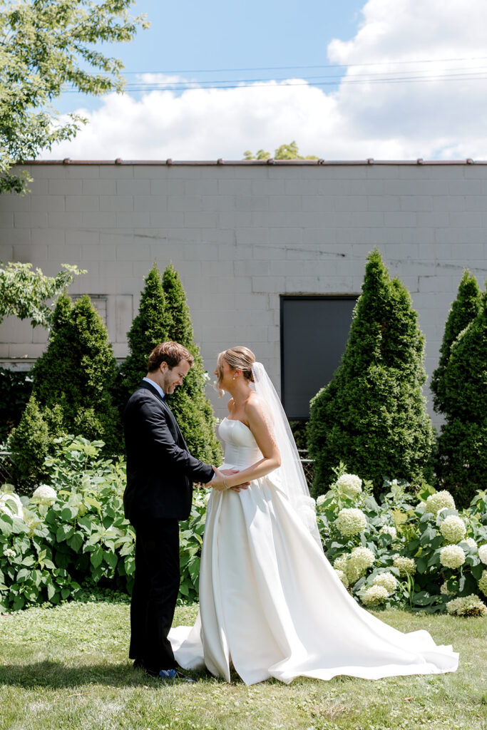 Couple holding hands during first look, a beautifully intimate first look wedding photo in natural light.