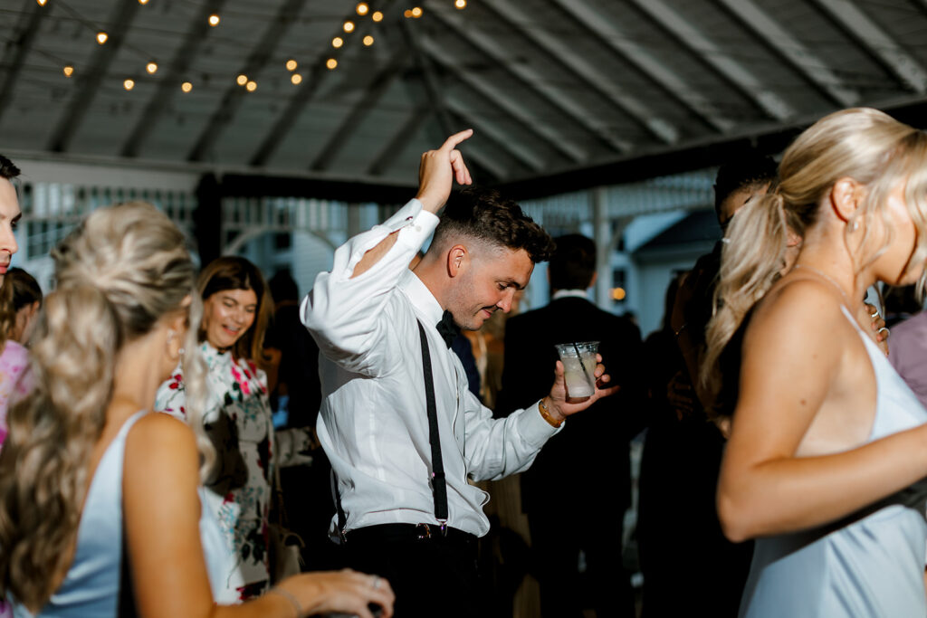 Guests dancing with drinks in hand, joyful energy at this Michigan wedding celebration.
